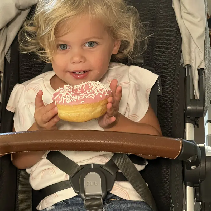 A young guest holding a sprinkled donut