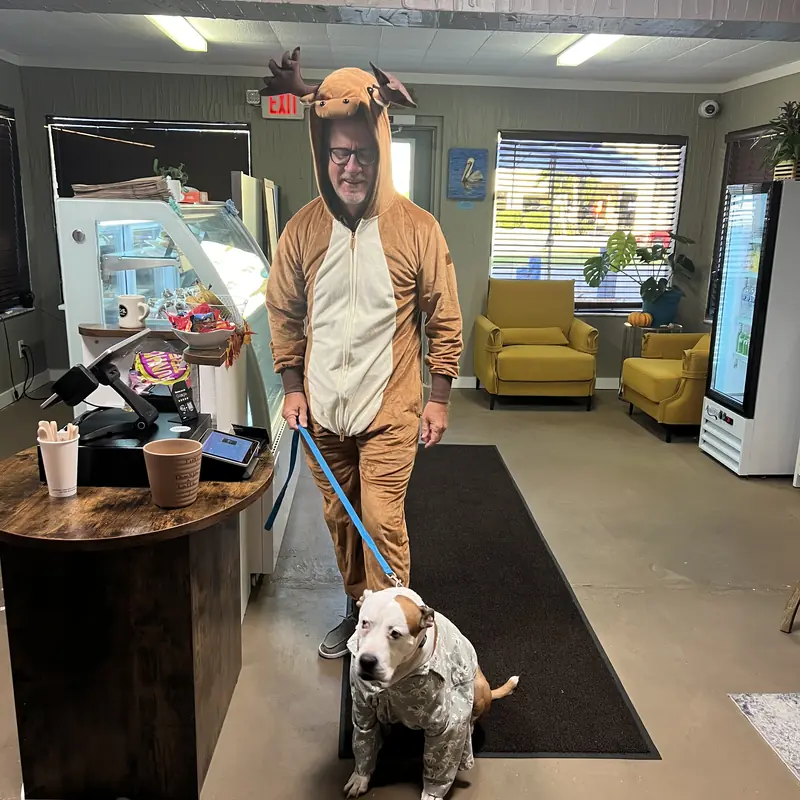 A guest and a dog, both in Halloween costumes, inside the shop