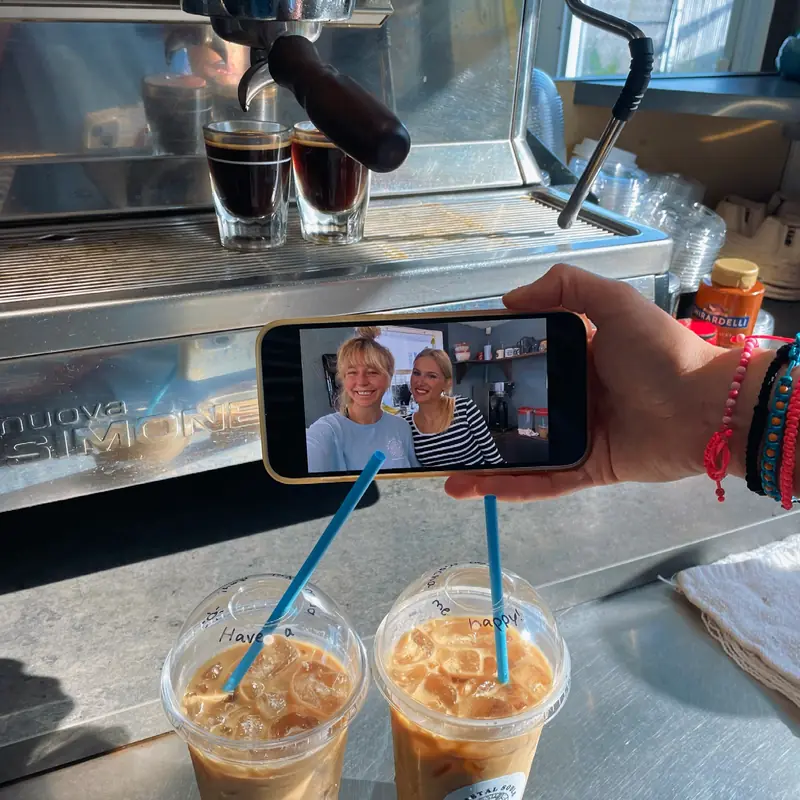 Two iced coffees on the counter by the espresso machine