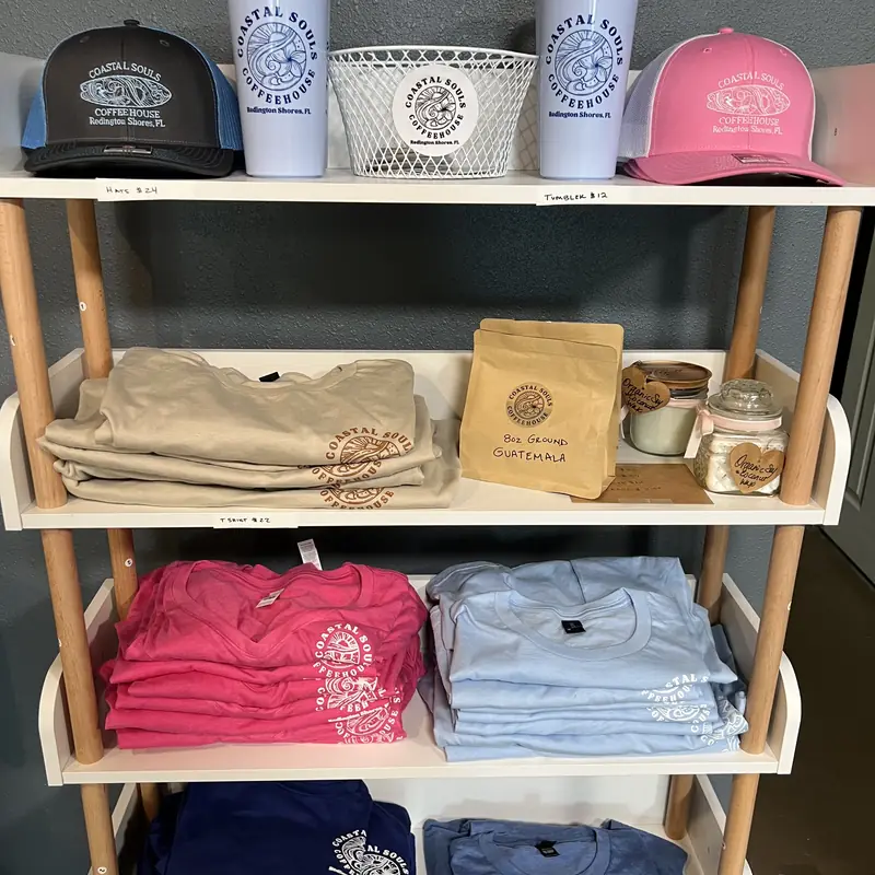 Coastal Souls merch on the shelf: hats, tumblers and t-shirts